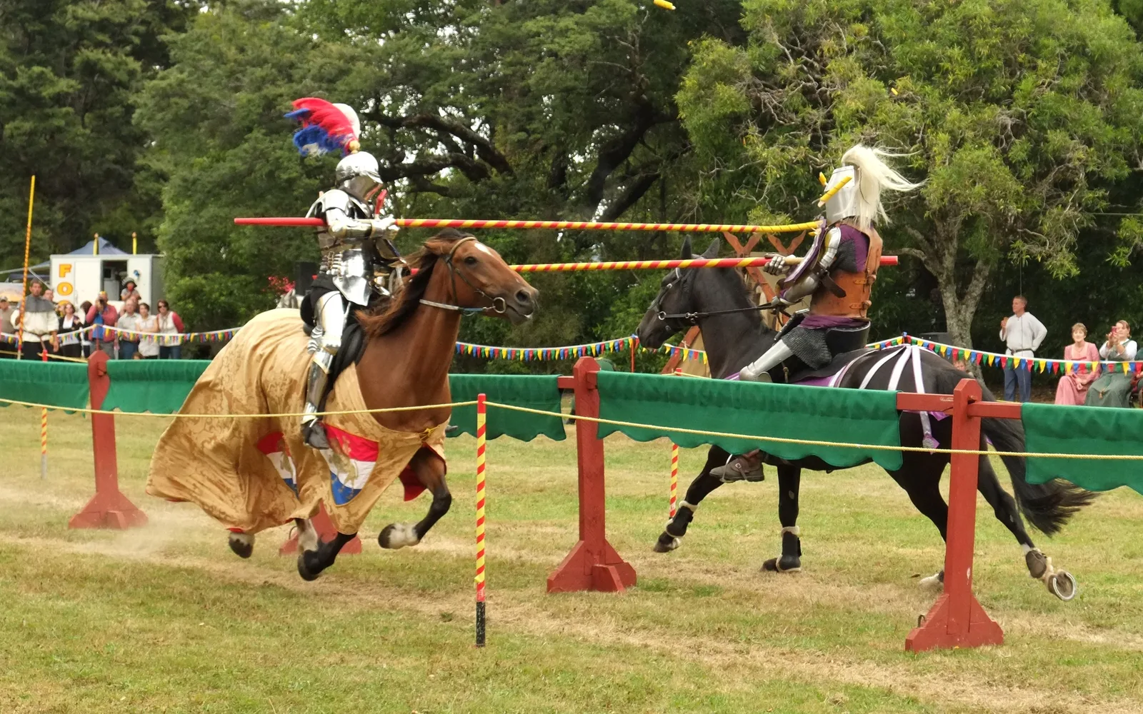 Two armored knights on horseback engaged in a jousting tournament, with lances breaking on impact with shields